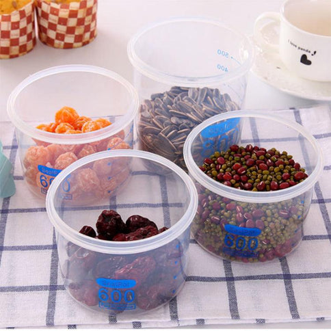 Set of transparent sealed plastic food storage containers filled with various snacks and legumes on a checkered tablecloth