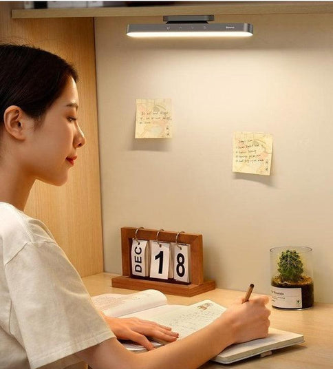 A magnetic charging lamp for dormitory providing stepless dimming, illuminating a student studying at a desk