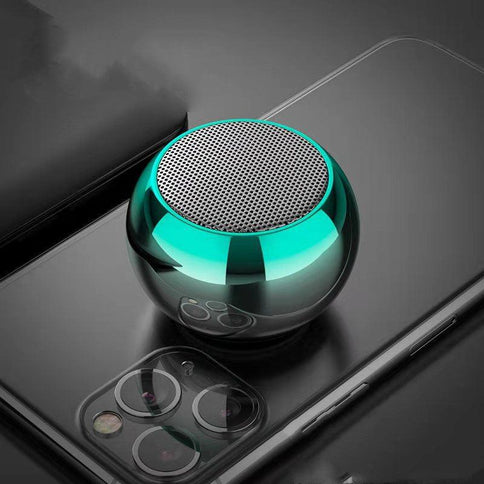 Compact and stylish portable Bluetooth speaker with high volume, designed for outdoor use, resting on a smartphone