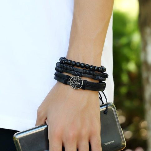 Stylish Tree of Life leather bracelet for men featuring intricate charm design, paired with black beaded bracelets.