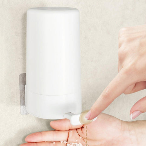 A wall mounted soap grinder in white, designed for convenient use, dispensing soap flakes easily into a hand