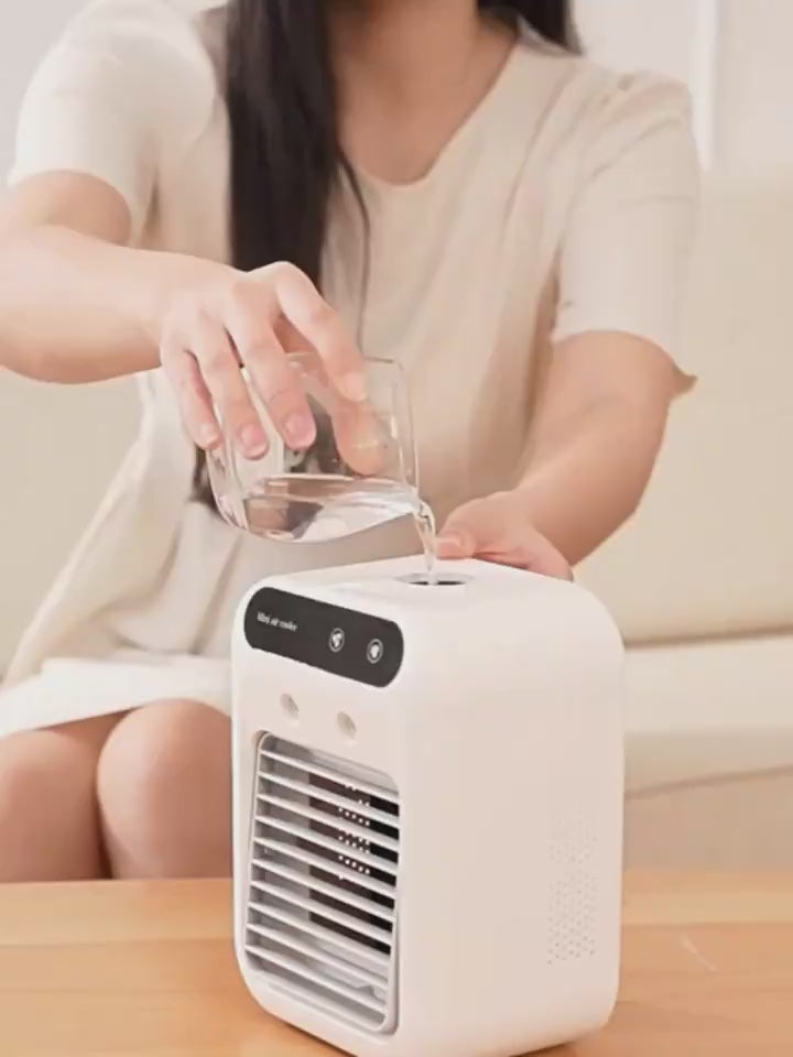 User pouring water into a portable water cooling fan for office use, showcasing its compact design and easy operation