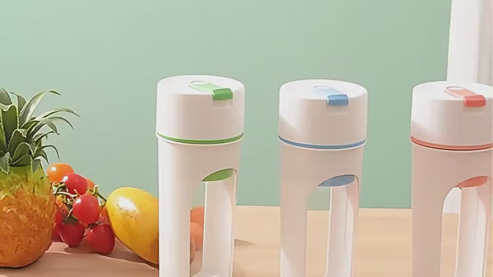 Multi-functional juicer squeezer in three colors on a kitchen counter next to fresh fruits and vegetables, perfect for healthy drinks