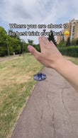 A person prepares to launch an LED flying drone toy on a park path, showcasing a fun interactive decompression experience.