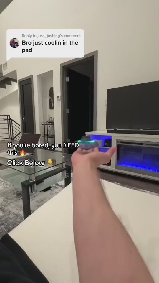 Mini fingertip gyro LED flying drone toy being controlled effortlessly in a modern living room setting