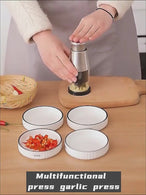 User demonstrating a multifunctional garlic press and vegetable chopper with freshly chopped garlic and peppers on a wooden cutting board